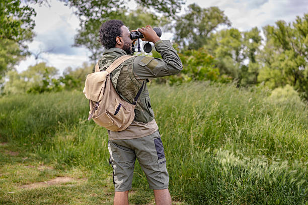 istock Young man enjoys birding adventure in a lush forest during a weekend exploration 2217812401