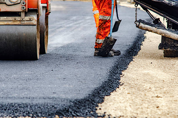 istock Construction workers in high-visibility gear are applyin gfresh hot asphalt to roadway surface 2217812420