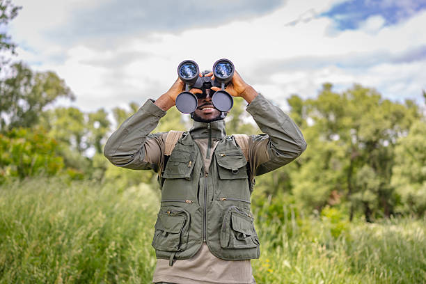 istock Young man enjoys birding in a lush outdoor forest, exploring nature with binoculars on a cheerful weekend adventure 2217812526