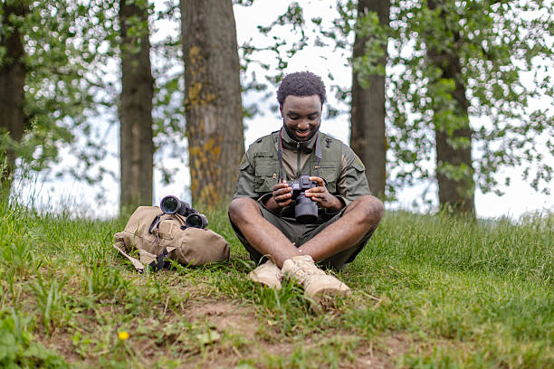istock Young man exploring birding with camera in a lush forest during a weekend adventure 2217812764