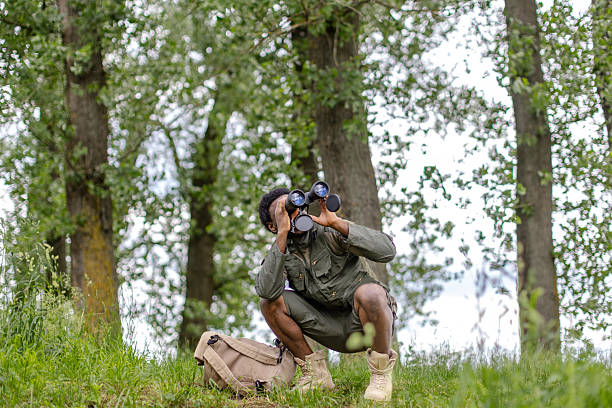 istock Young man observing birds in a lush forest while enjoying nature and the outdoors with binoculars 2217812849