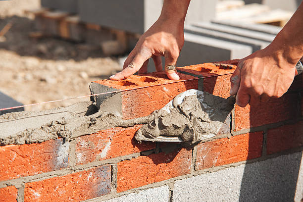 istock Close-up of Skilled worker laying bricks with trowel on construction site 2217812933