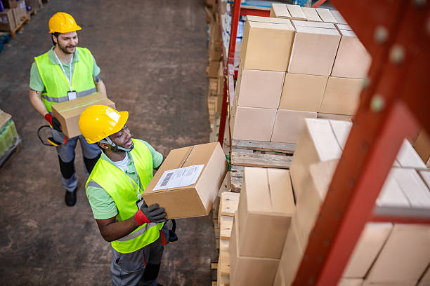 istock Warehouse workers strategically handling boxes in a busy distribution center during daylight hours 2217813122