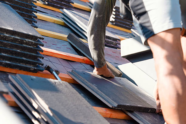 istock Roofer installing roof tiles using nails and hammer 2217813671