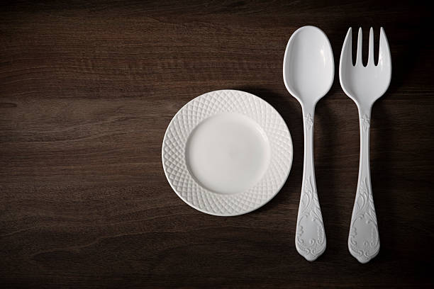 istock large  plastic fork and spoon and little plate on dark wooden table 2217815061