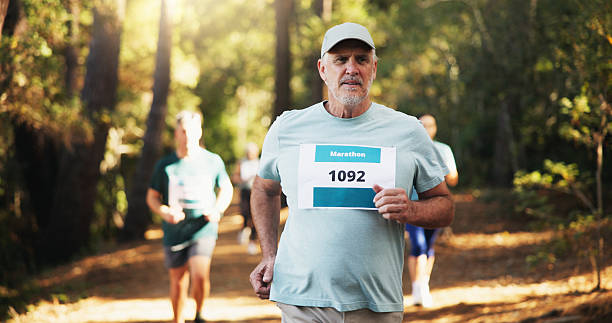 istock Cardio, marathon and running with man in forest for challenge, performance or race. Action, competition and fitness with mature runner at rally event in nature or woods for course, heat or trial 2217815346