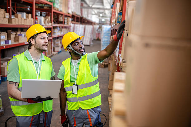 istock Warehouse workers examining merchandise in distribution center while ensuring safety protocols are followed 2217815349