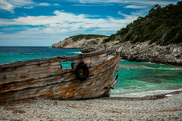 OLD ABANDONED WOODEN BOAT IN NORWEGIAN FJORD LANDSCAPE - Concept of nostalgia, solitude, adventure, rustic travel, maritime heritage and scenic nordic nature with fjord horizon
