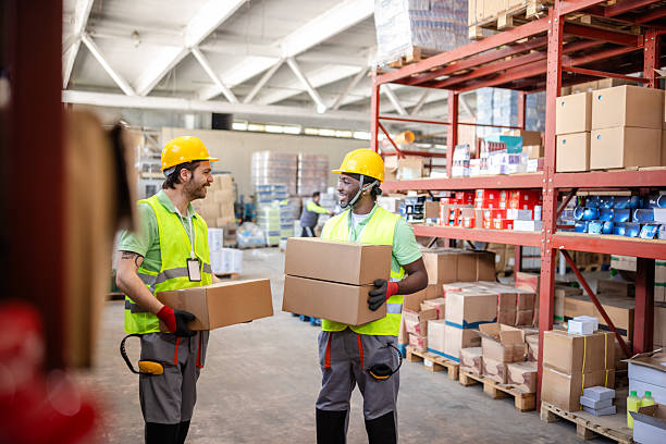istock Warehouse workers collaborating on packaging and shipping tasks in a busy distribution center during daylight hours 2217817538
