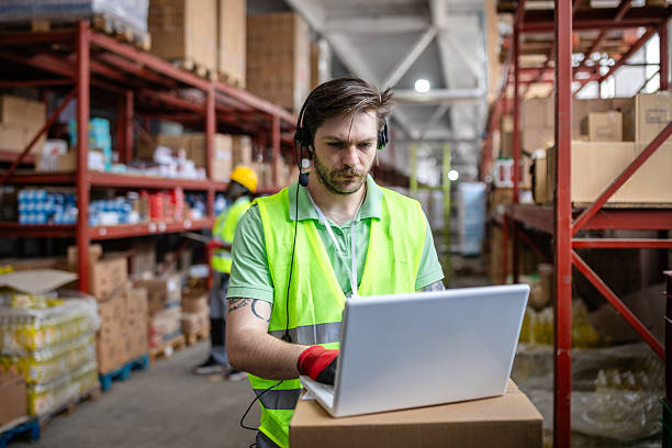 istock Warehouse worker using laptop to manage inventory in e-commerce distribution center 2217819107