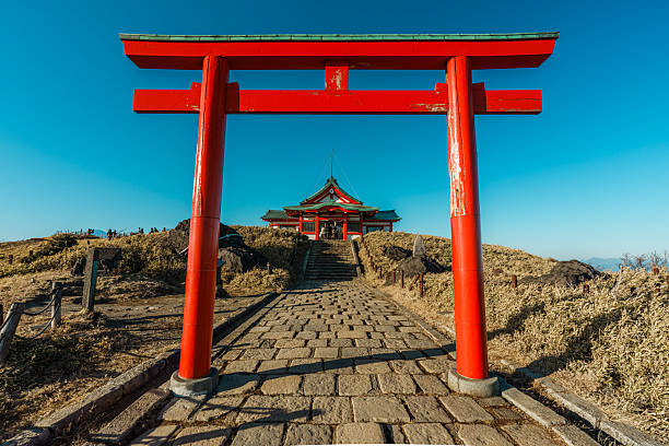 Hakone, Japan - Dec 10, 2023: A red torii gate leads to the mountaintop Hakone Mototsumiya Shrine under a clear sky. Hakone, Japan.