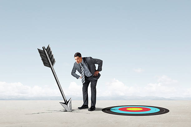 istock Man Looks Down At Arrow That Missed Its Mark 2217825661