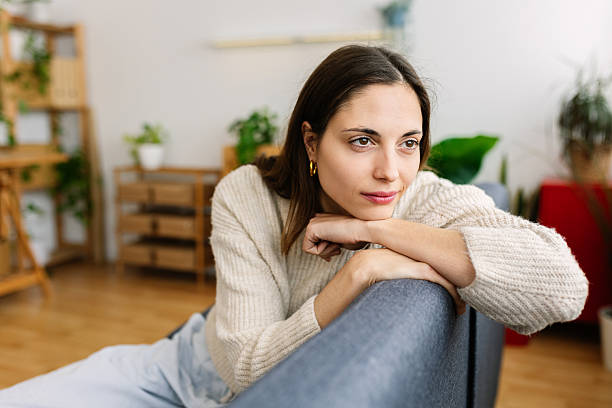 istock Young woman relaxing on sofa at home, enjoying quiet moment 2217825739