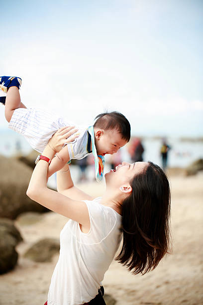 istock Mother lifting baby joyfully outdoors 2217827651