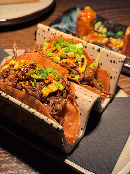 Delicious pulled beef pork taco with scallion herb topping served in modern gourmet restaurant for dinner appetizer