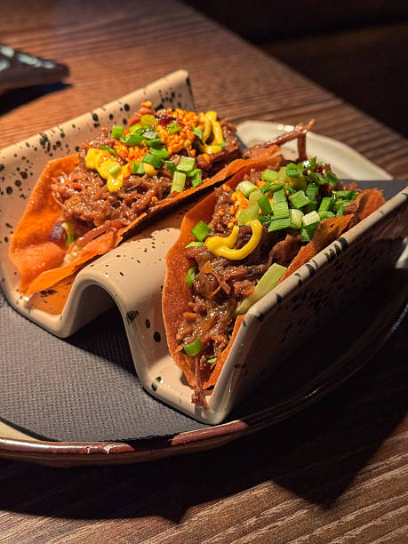 Delicious pulled beef pork taco with scallion herb topping served in modern gourmet restaurant for dinner appetizer