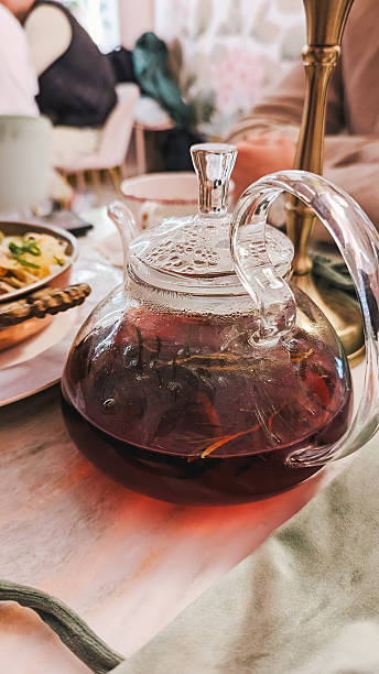 istock Glass teapot filled with herbal tea, marble table, restaurant setting 2217828577