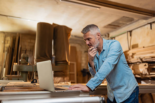 istock Man Working on Laptop in Woodworking Shop Environment 2217828928