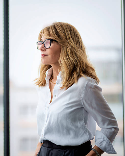 istock Attractive blond haired woman standing at glass wall 2217828992
