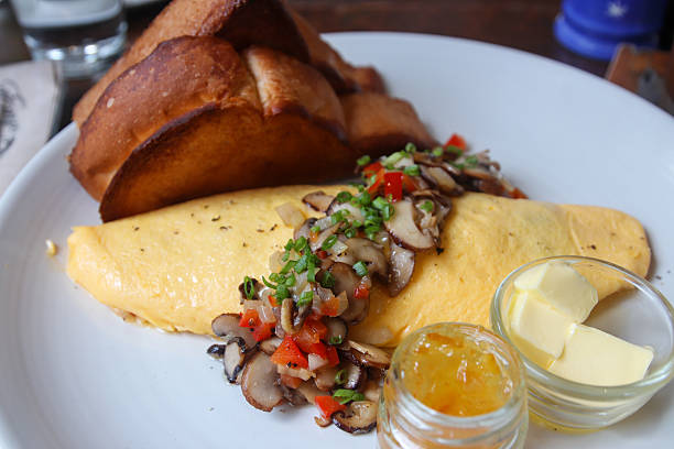 Omelet with mushrooms, sauce, and toast on a plate