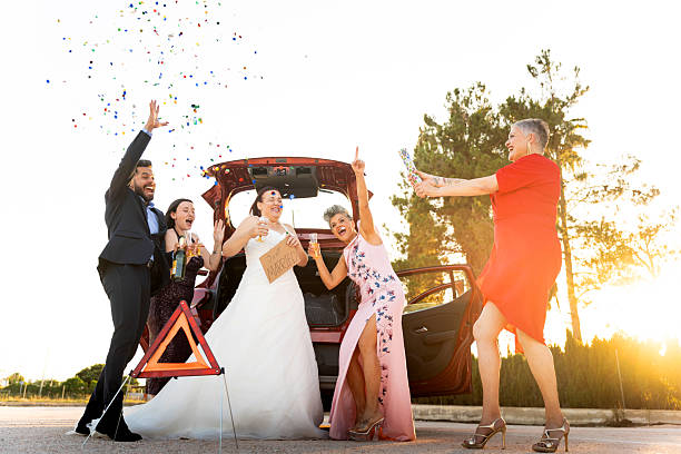 istock Bride and friends celebrating wedding after roadside breakdown 2217829631