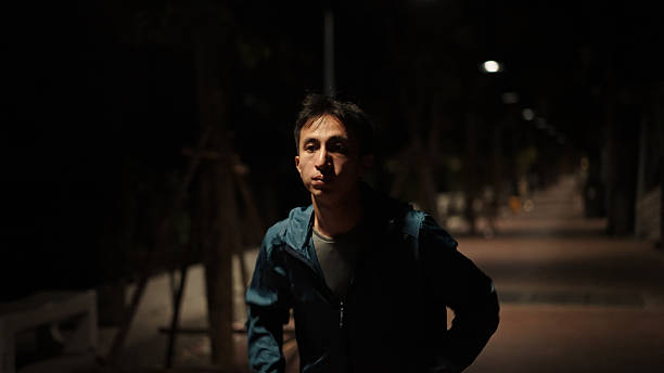 Asian man jogging in the city at night.