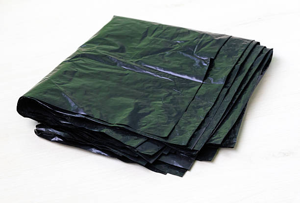 istock Folded black garbage bags isolated on white background. These are plastic polyethylene waste bags for trash bins. 2217834003