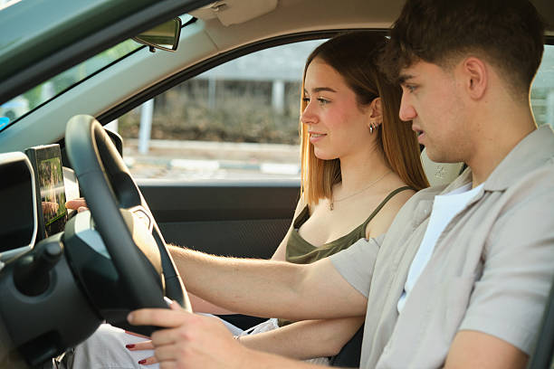 istock Young couple driving modern electric car using gps navigation system 2217835195