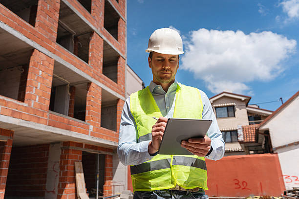 istock Engineer inspecting construction site and reviewing building plans on digital tablet 2217839019