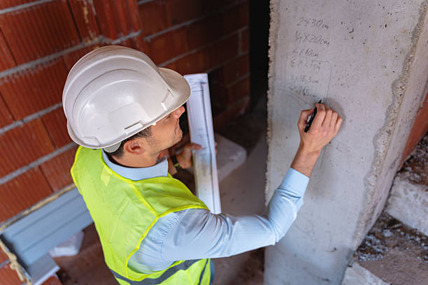 istock Engineer inspecting construction site and recording measurements on concrete pillar 2217839065
