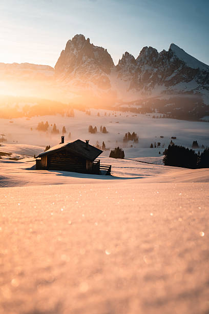 Mountain hut on snowcapped mountain at dawn, Dolomites
