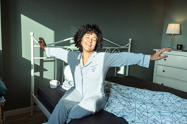istock Woman stretching on bed in a cozy morning light environment 2217841483