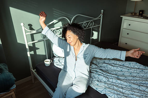 istock Woman stretching on bed in a cozy morning light environment 2217841486