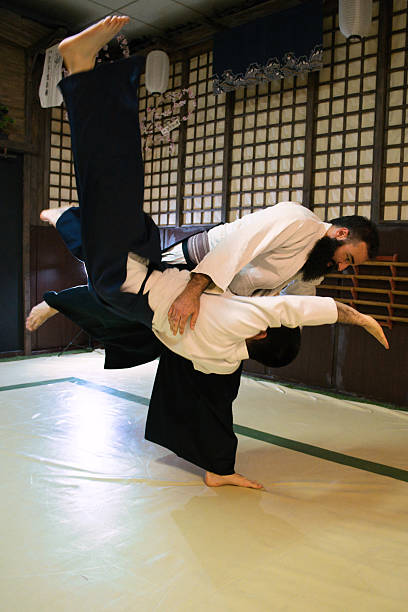 istock Two aikido practitioners, in a Japanese style dojo, executing an unbalancing technique. 2217841981
