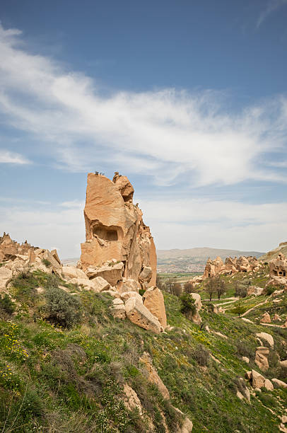 Eroded rock formations define Cappadocia's landscape in Turkey. Volcanic rock sculpted by time creates a unique, otherworldly scene under a blue sky.