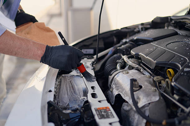 istock Car detailer cleaning engine compartment with brush and detergent 2217844570