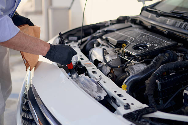 istock Mechanic cleaning car engine compartment with brush and detergent 2217844573