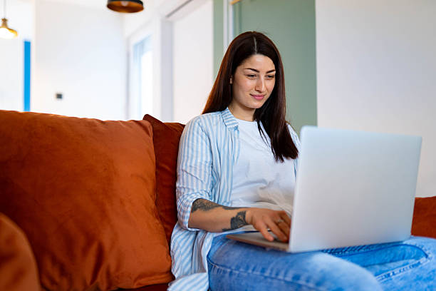 istock Woman using laptop at home on sofa 2217844844