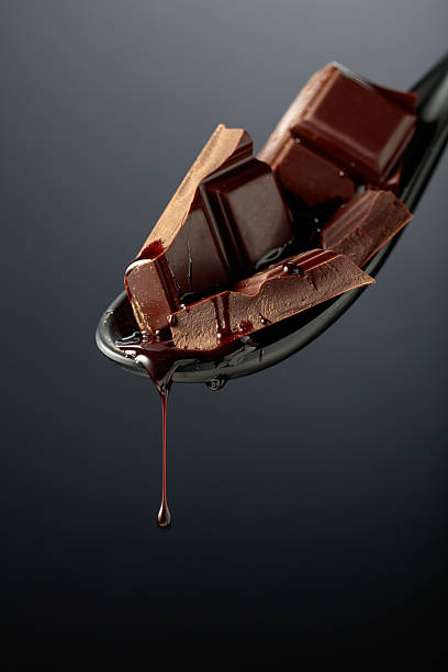 istock Melting pieces of bitter chocolate on a black background. 2217845549