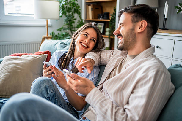 istock Couple relaxing on sofa, browsing social media and having fun 2217845683