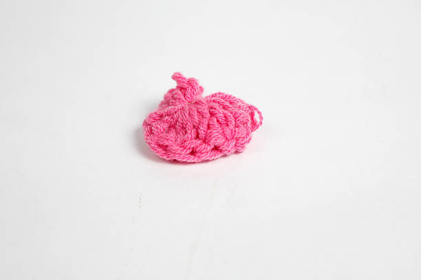 heart shaped handmade accessory made of pink wool fabric, isolated on white background