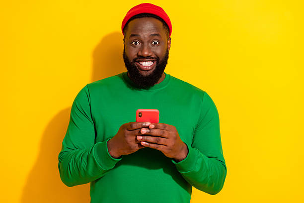 istock Portrait of attractive cheerful guy using device chatting post influencer isolated over bright yellow color background 2217849555