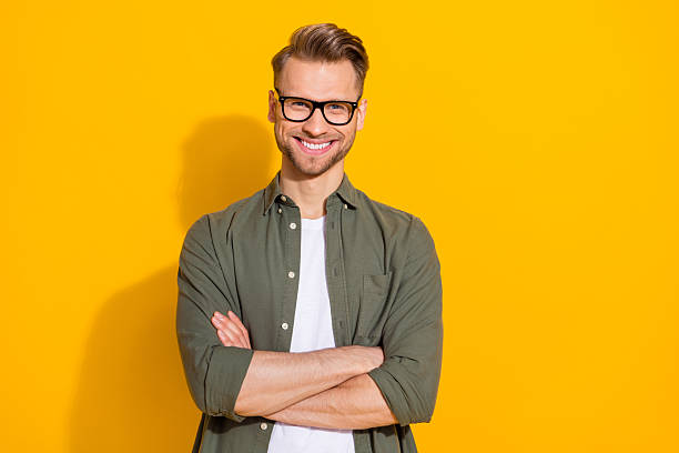 istock Portrait of attractive cheerful content intellectual guy folded arms isolated over bright yellow color background 2217849721