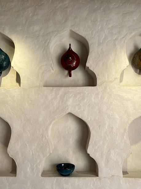 istock Colorful ceramic vases and bowls displayed in ornate white wall niches 2217854529