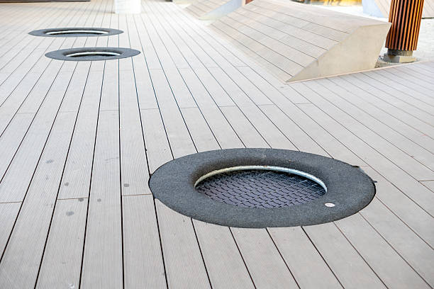 istock Multiple in-ground trampolines embedded in public wooden decking provide fun recreational play opportunity in modern urban playground design feature 2217859481
