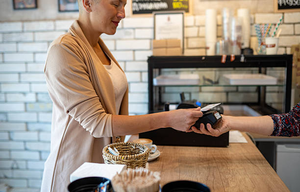 istock Woman paying for coffee with a card 2217860681