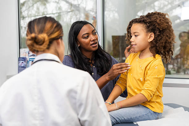 istock Doctor Talking with Mother and Daughter During Checkup 2217861586