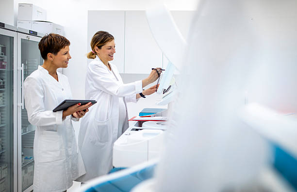 istock Mid Adult Female Lab Professionals Analyzing Samples in a Bright Clinical Laboratory Setting 2217864079