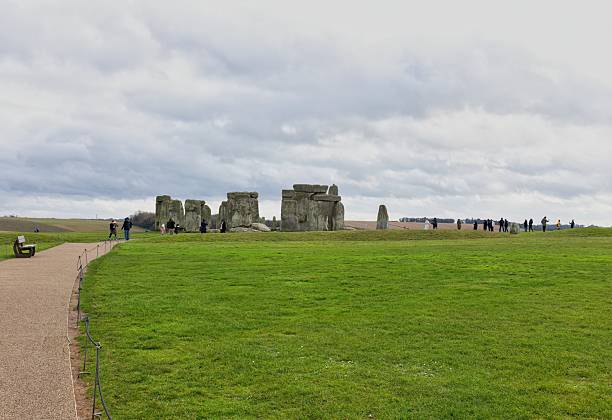 Stonehenge stands majestically in a green field under a cloudy sky at Stonehenge - Wiltshire - Great Britain