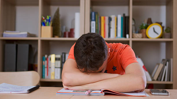 Teenager boy tired stressed of reading, doing homework